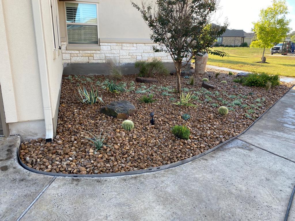 Flower beds with native Texas plants and rock ground cover